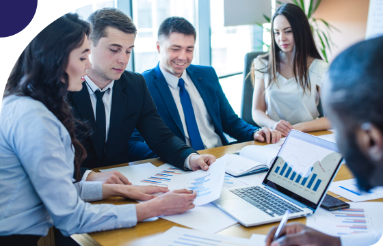 Two hands shaking over financial documents