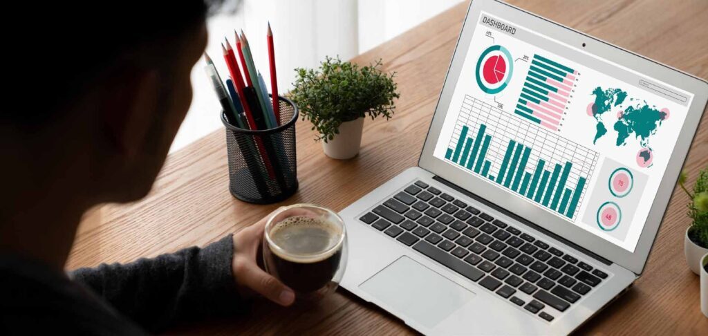A person analyzing a dashboard on a laptop